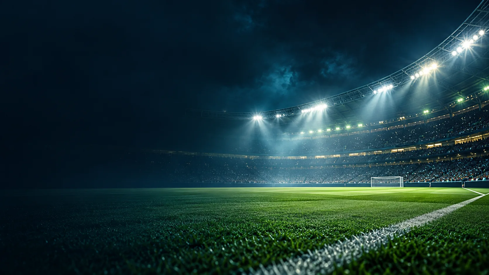 A floodlit football stadium viewed from the touchline